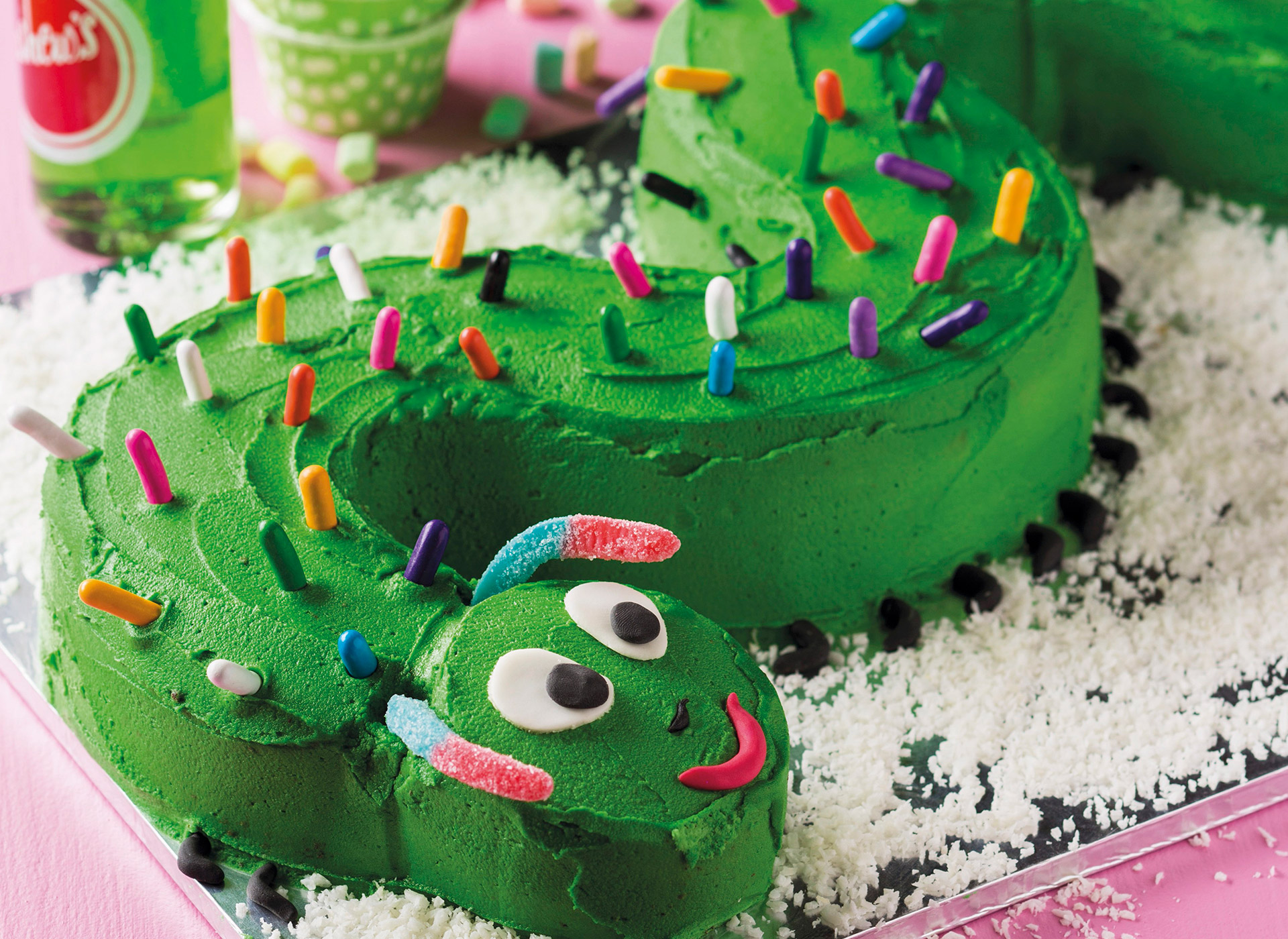 Bursdagskake formet som en grønn slange. Foto.