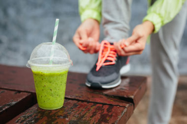 Grønn smoothie som mat etter trening og dame som knyter joggesko
